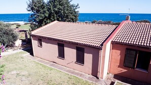 A two-story building with a tiled roof, a small garden, and a view of the sea. - Charming house/villa panoramic sight on sea 6 persons (Villaputzu)