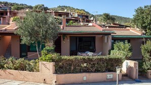 A Mediterranean-style building with terracotta tiled roofs, a covered patio with outdoor furniture, and a hillside backdrop. - Charming house/villa panoramic sight on sea 6 persons (Villaputzu)