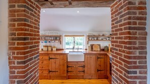Una cocina con armarios de madera, una isla central y un ventanal.