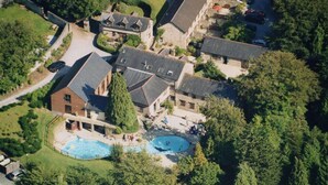 An aerial view of a residential area with multiple houses, a swimming pool, and a tennis court.
