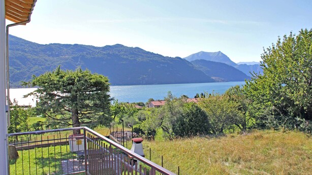 A balcony with a view of a lake and mountains.