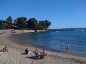 A beach with people relaxing and swimming.
