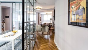 A modern interior with a glass partition, a dining area with a white table and striped chairs, and a framed artwork on the wall. - Seville center, large penthouse with terrace and 3 double bedrooms (Sevilla)