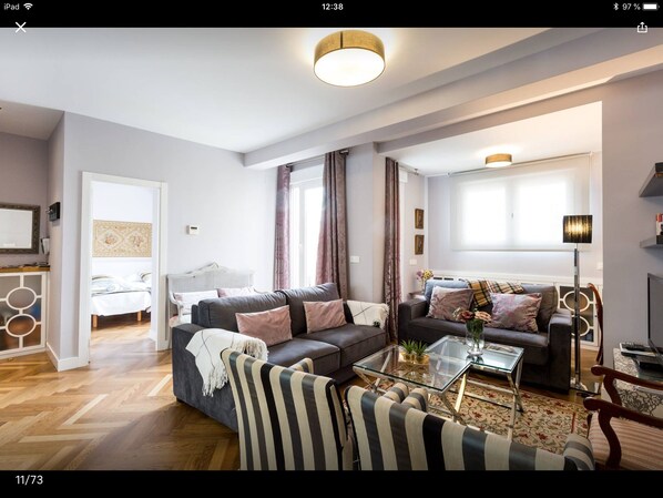 Un salon moderne comprenant un canapé, une table basse et un fauteuil à rayures.