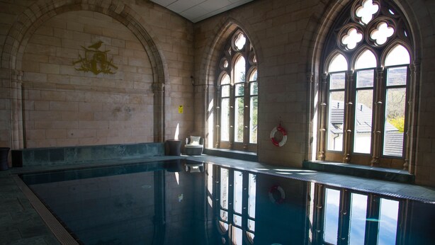 A large indoor swimming pool with arched windows and stone walls. - 3 bedroom 2nd floor apartment to sleeping 8 with stunning views of Loch Ness. (Loch Ness)