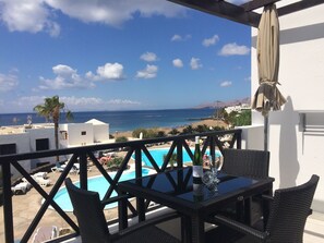 A balcony with a pool, wicker furniture, and a view of the beach and ocean. - Front line, contemporary, stunning sea views, pool, WiFi, SKY (Tías)