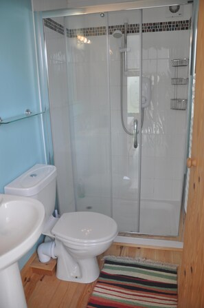 Ein Badezimmer mit Toilette, Waschbecken und einer Duschkabine.