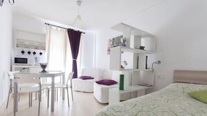 Een moderne, minimalistisch ingerichte kamer met een bed, een bureau en een stoel.
