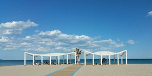 Ranta lähistöllä, aurinkotuoleja, rantapyyhkeitä