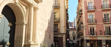 A narrow street with buildings on either side, including a building with a sign that reads "MALLORCA".