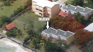 Hotel à beira-mar com vários edifícios, praia e palmeiras.