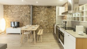 Eine moderne Küche mit Steinwänden, Holzmöbeln und integrierten Geräten.