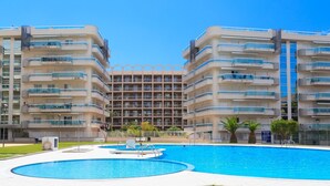 Ein modernes Apartmenthaus mit einem zentralen Innenhof und einem Schwimmbecken.