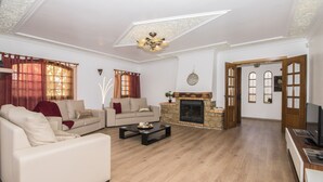 A living room with a fireplace, a sofa set, a coffee table, and a television.