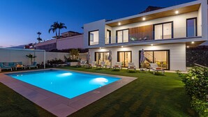 A modern two-story house with a swimming pool, outdoor seating, and a well-maintained lawn. - Beautiful Villa for 6 people, WiFi, private and heated pool, 8min from the beach (Costa Adeje)