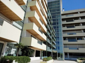 A modern multi-story building with balconies, large windows, and a clear sky. - VilamouraSun Aquamar 110 -  Pool and Marina View (Quarteira)