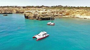 A coastal area with boats, rocky cliffs, and clear blue water. - VilamouraSun Aquamar 110 -  Pool and Marina View (Quarteira)