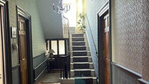 A hallway with a staircase, wooden floors, and patterned walls. - Detached Period Home-Former Rectory, Views Of Bristol Channel/Gower & Caldy (Narberth)