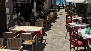 En gade med udendørs siddepladser, en café og en restaurant med et Guinness skilt.