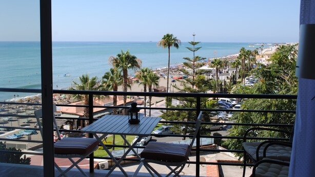 A balcony with a view of the beach, palm trees, and parked cars. - Renovated studio on the beachfront, wifi, satellite TV and air conditioning (Torremolinos)