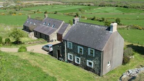 A stone house with multiple chimneys and a car parked in front. - Remote Peaceful Cottage. Great for families. Panoramic Views & Skies. Fresh Air. (St. Nicholas)