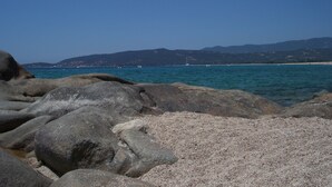 A rocky shoreline with clear blue water and distant mountains. - Splendid villa 5 minutes from the sea (Sollacaro)