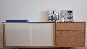 Ein Holzkabinent mit weißer Tür und drei Schubladen.