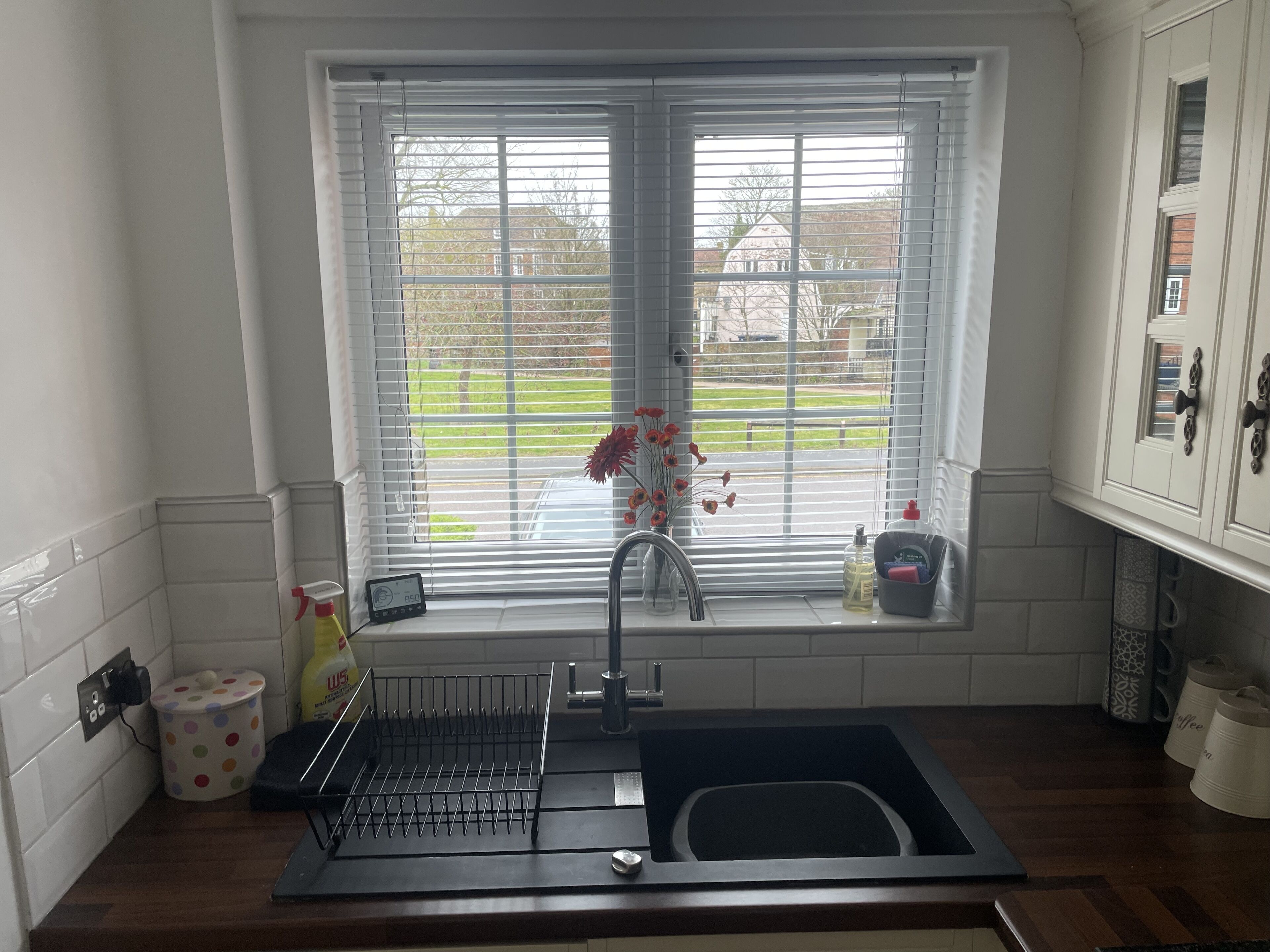 Una cocina con ventana, lavamanos y encimera.