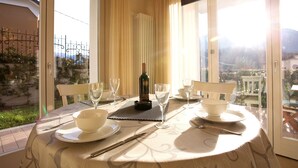 Mesa de comedor dispuesta con copas de vino, cuencos y cubiertos, con una botella de vino y un radiador al fondo.
