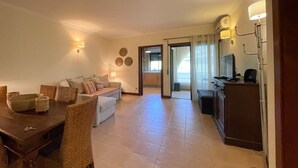 Uma sala de estar moderna com área de jantar, cozinha e vista para o exterior.