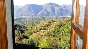A view from a window overlooking a mountainous landscape with a town in the valley below. - Barga -cottage & barn 6 hctres of land, private pool, WIFI , stunning views! (Barga)