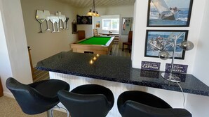 Taula de bitlles en una sala amb zona de bar, quadres a la paret i un tir d'imanes.