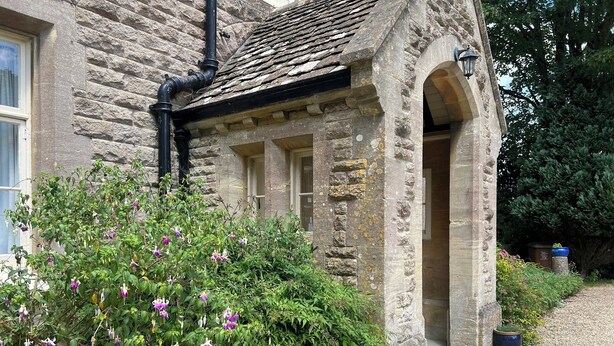 A stone building with a traditional design, including a stone archway and a window with shutters. - 10-16 persons. Variable rates. 4 large (20-25 sq mtr) en suite rooms. (Colerne)