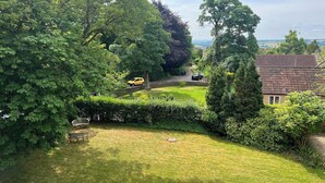 A lush green garden with a bench, a pathway, and a view of a distant landscape. - 10-16 persons. Variable rates. 4 large (20-25 sq mtr) en suite rooms. (Colerne)