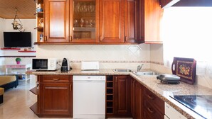 A kitchen with wooden cabinets, a microwave, a toaster, and a dishwasher.