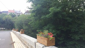 Un trottoir bordé d’une barrière en béton et de jardinières.