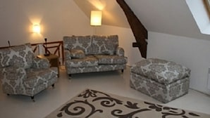 Une pièce mansardée chaleureuse, avec des meubles à motifs, un tapis décoratif et un plafond en pente.