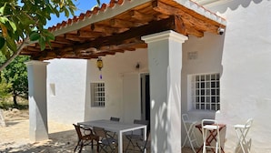 An outdoor patio with a table and chairs, a pergola, and a white wall with windows. - 🔑🔑🔑🔑Villa Can Mestreso New Suite Ibiza ETV1227E👍👍👍👍👍👍 (Ibiza)