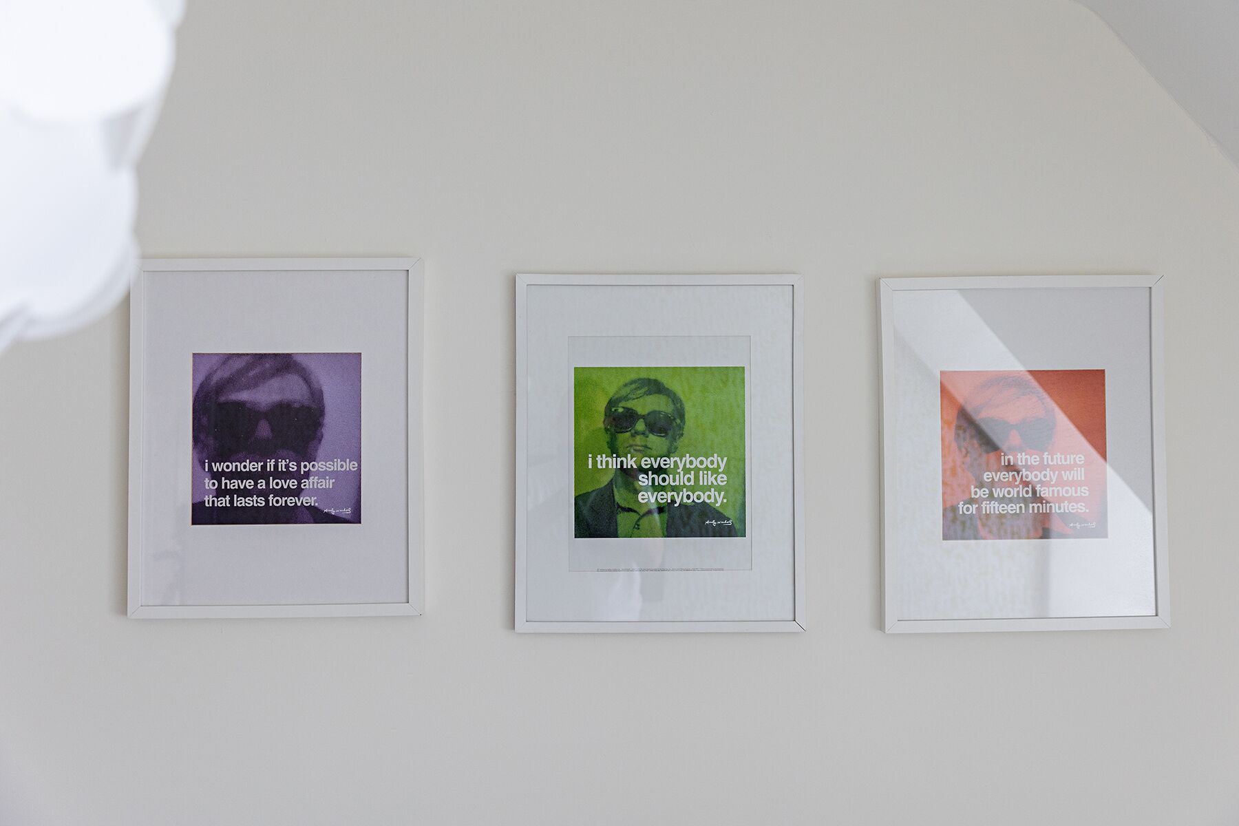 Tres frases enmarcadas sobre una pared.