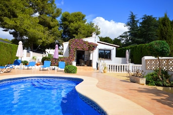 Pool with villa in the background.