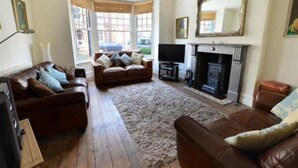 A living room with a fireplace, leather sofas, and a large mirror.