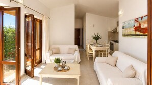 A spacious living area with a sofa, a coffee table, and a dining table set for four.