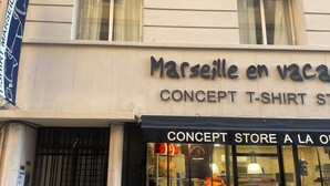 Liiketila, jonka edessä on kyltti, jossa lukee: ”Marseille en vaca” ja ”CONCEPT T-SHIRT STORE”.