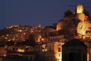 A historic town with illuminated buildings and a prominent clock tower on a hill. - Vico Muccio - historical house, finely restructured with a splendid view on the historical Baroque city of Modica (Modica)