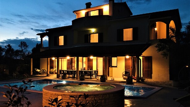 Une grande maison avec une piscine et un espace extérieur aménagé pour se détendre.