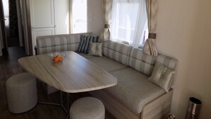 Ein gemütlicher Wohnbereich mit einer Couch, einem Tisch und einem Fenster mit Vorhängen.