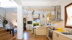 A modern kitchen with wooden flooring, a central island, and a built-in oven.