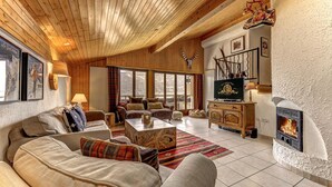 A cozy living room with wooden ceilings, a fireplace, and comfortable seating. - Penthouse les Telecabines - La Tzoumaz, 4 Vallees (La Tzoumaz)
