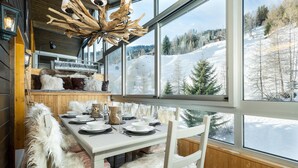 A cozy dining area with a large window overlooking a snowy landscape. - Penthouse les Telecabines - La Tzoumaz, 4 Vallees (La Tzoumaz)