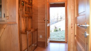 Un corridoio interno in legno con una porta che dà sull'esterno.
